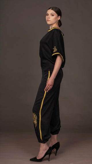 woman wearing a modern black designer outfit with golden leopard embroideries from #Mary and Mary#